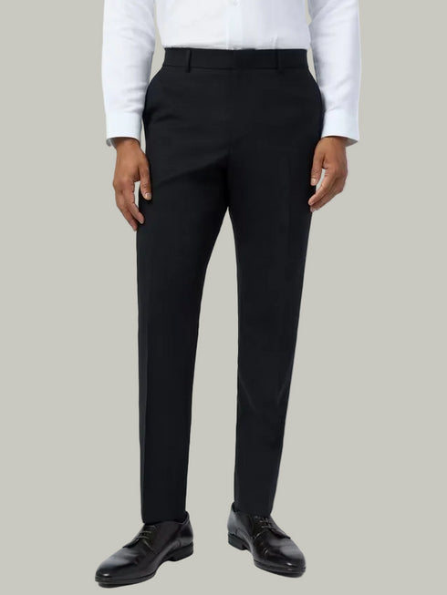 Person wearing black dress pants with a white shirt on a white background