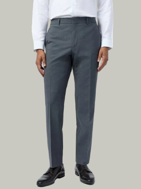Person wearing gray dress pants with a white shirt on a light gray background