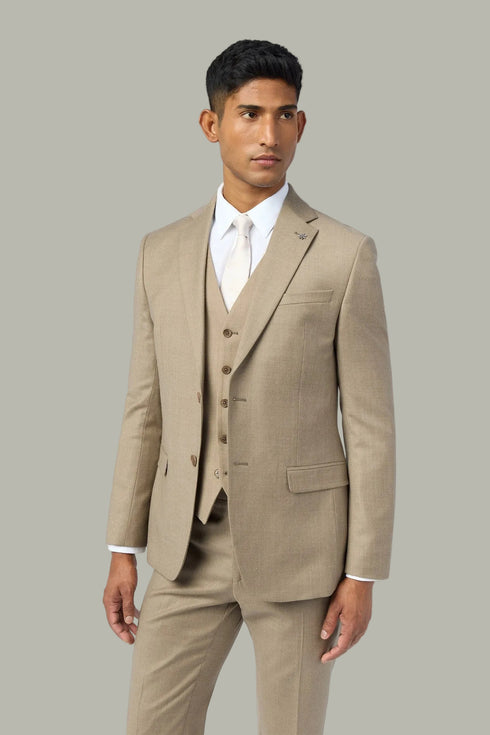 Man wearing a beige suit with a white shirt on a light gray background