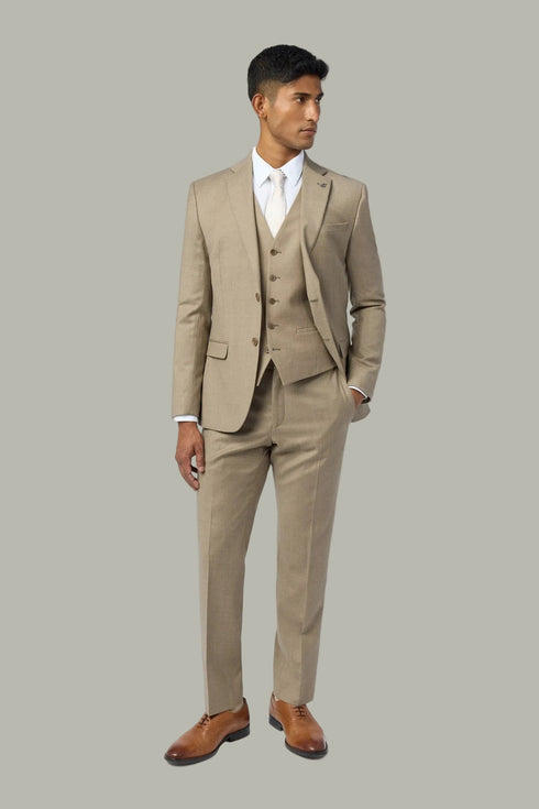 Man wearing a beige suit with a white shirt on a light gray background