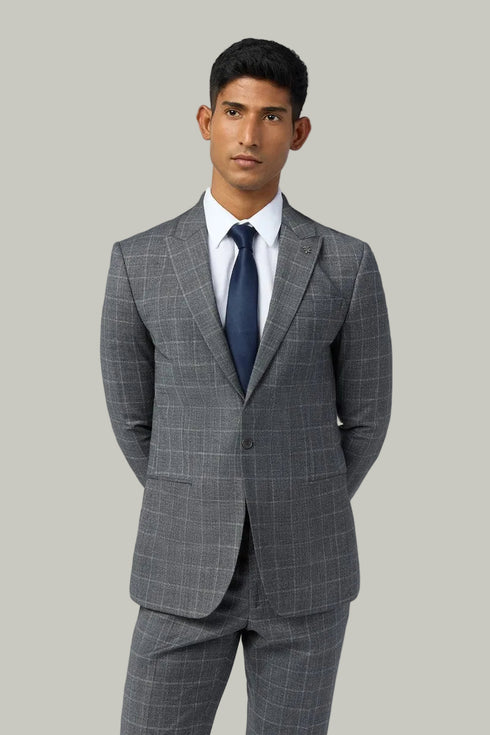 Man wearing a gray checkered suit with a blue tie on a white background