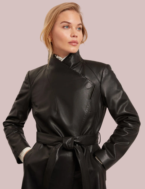 Woman wearing a black leather coat against a plain background